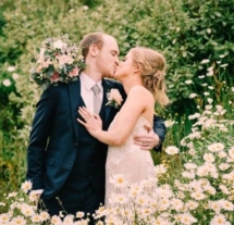 A couple kissing in a flower-filled garden at Fernhill House Hotel.