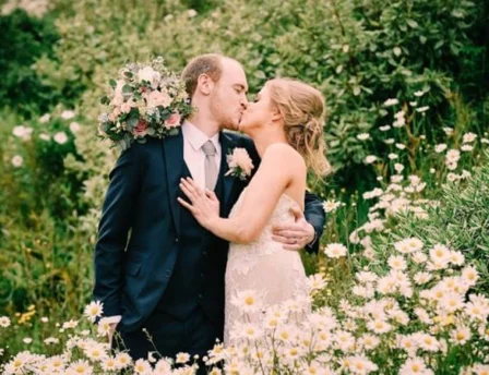 Couple kisses in a flower-filled garden at Fernhill House Hotel.