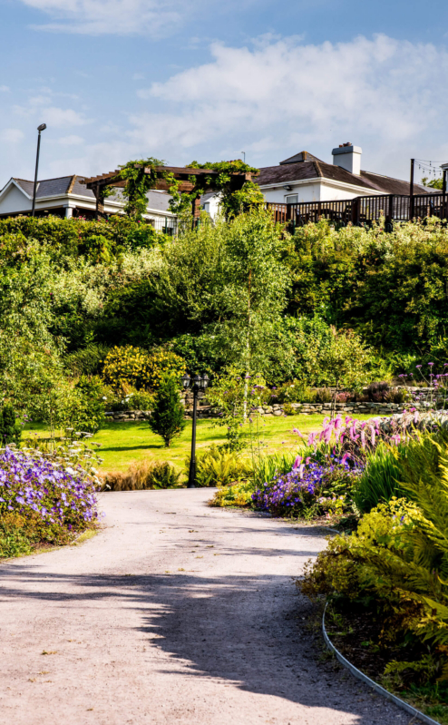 Family enjoying gardens at Fernhill House Hotel, with vibrant flowers and bright skies.