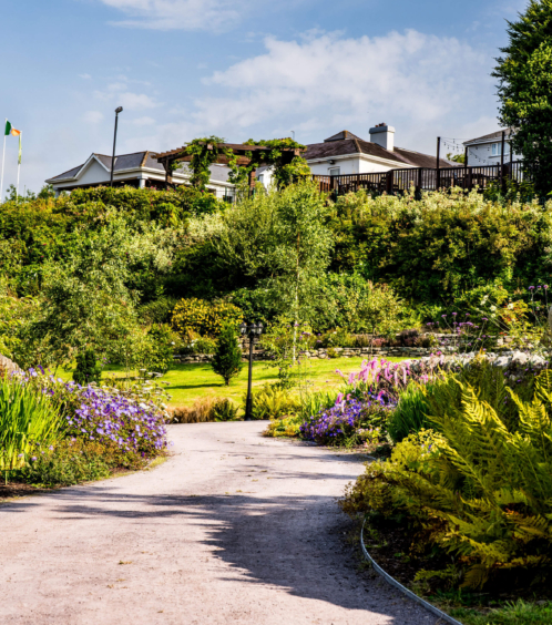 Family enjoying gardens at Fernhill House Hotel, with vibrant flowers and bright skies.