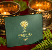 Elegant Fernhill card with lit candles and fern leaves.