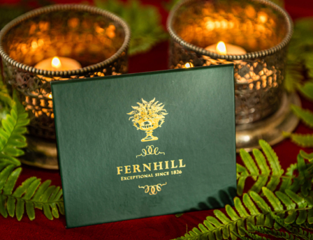 Elegant Fernhill card with lit candles and fern leaves.