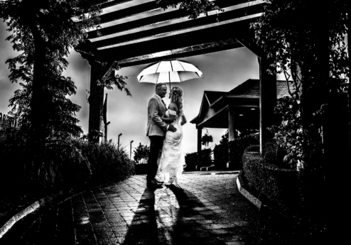 A couple shares a moment under an umbrella at Fernhill House Hotel.