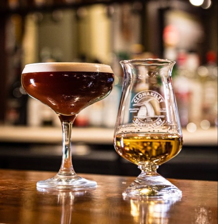 Cosy bar setting with elegant cocktail and whiskey