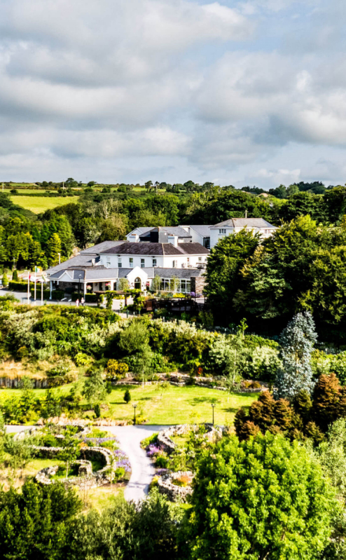 Aerial view of Fernhill House Hotel surrounded by lush gardens and countryside.