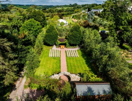 Serene outdoor wedding setup in lush gardens at Fernhill House Hotel.