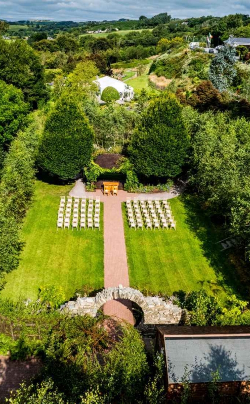 Serene outdoor wedding setup in lush gardens at Fernhill House Hotel.
