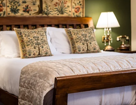 Cosy hotel room with double bed, decorative pillows, and warm lighting.