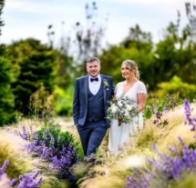 A couple walks joyfully through vibrant gardens at Fernhill House Hotel.