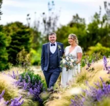 Couple walking through lush garden at Fernhill House Hotel.