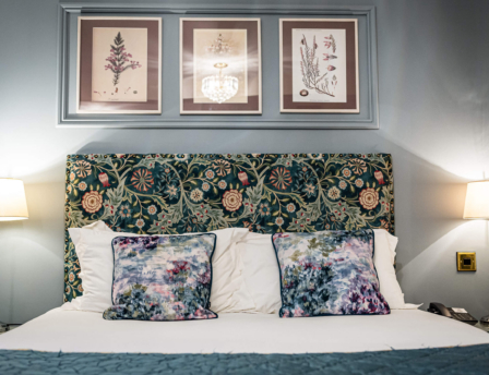 Cosy hotel room with floral decor and soft lighting.
