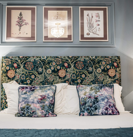 Cosy hotel room with floral decor and soft lighting.