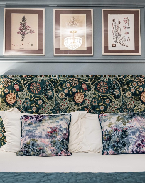 Cosy hotel room with floral decor and soft lighting.