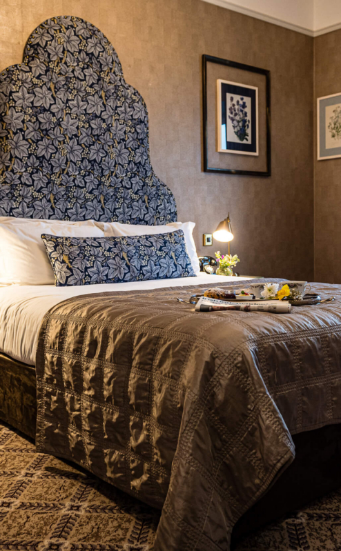 Cosy hotel room with plush bed, elegant decor, and natural light from window