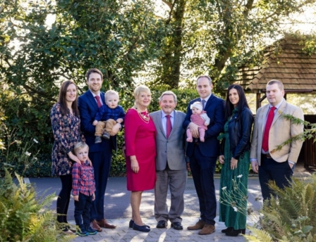 A happy family gathered together in a lush garden at Fernhill House Hotel.