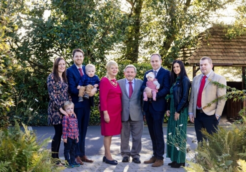A happy family gathered together in a lush garden at Fernhill House Hotel.