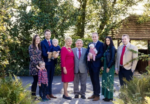 A joyful family gathers in garden at Fernhill House Hotel.