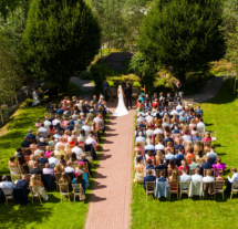 Outdoor wedding ceremony with guests seated on a lush green lawn at Fernhill House Hotel.