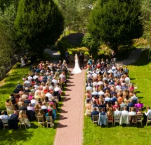 A couple weds in a serene garden setting at Fernhill House Hotel, surrounded by guests.