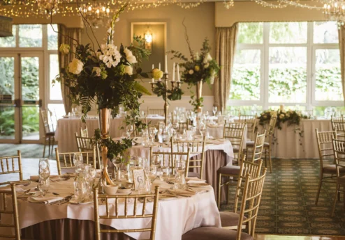 Elegant wedding reception in a sunlit Fernhill House Hotel ballroom with floral centrepieces.