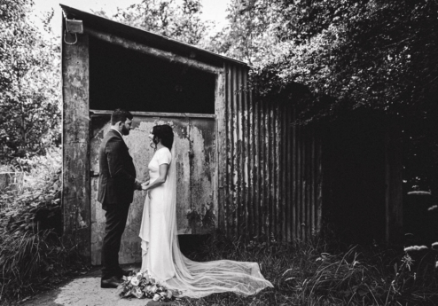 Couple sharing a tender moment outdoors near rustic shed.