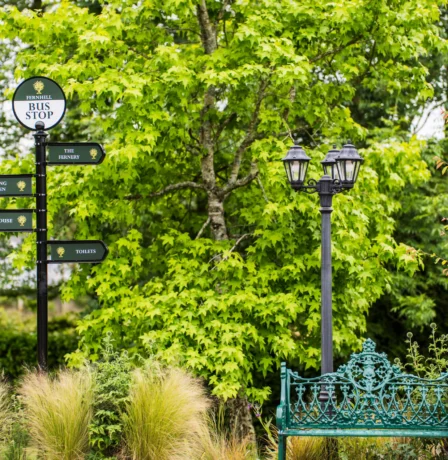 Family garden area at Fernhill House Hotel with seating and directional signs.