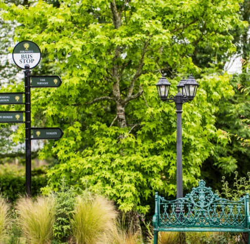 Family garden area at Fernhill House Hotel with seating and directional signs.