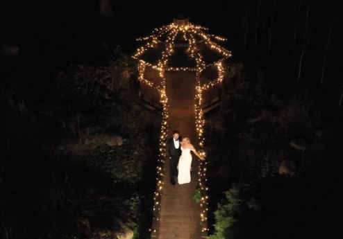 A couple stands on a fairy-lit path in a serene night garden at Fernhill House Hotel.