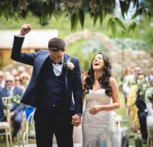 A joyful couple celebrating their wedding outdoors at Fernhill House Hotel.