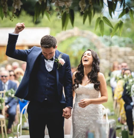 A joyful couple celebrating their wedding outdoors at Fernhill House Hotel.