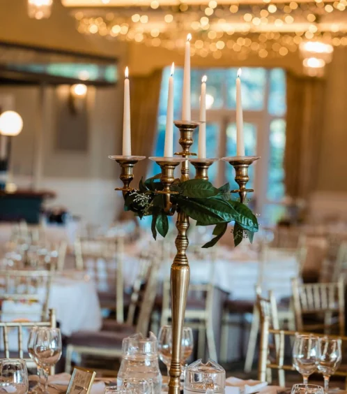 Elegant dining setup with candlelit candelabra and twinkling fairy lights.