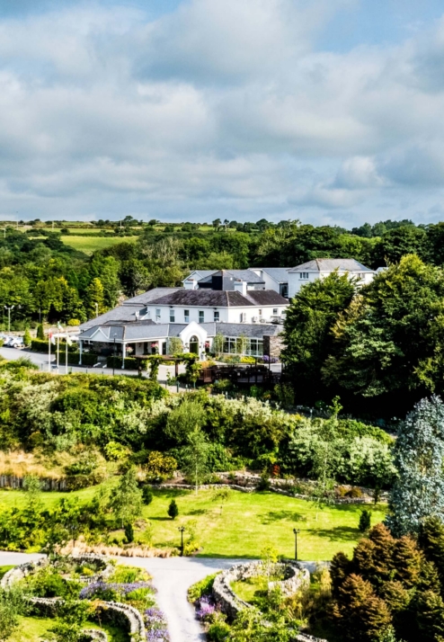 Charming Fernhill House Hotel nestled among lush green gardens and rolling countryside.