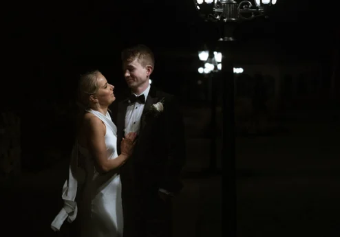 A couple enjoying a romantic evening stroll under charming streetlights.