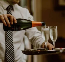 Waiter serving champagne in elegant hotel setting