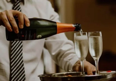 Waiter serving champagne in elegant hotel setting