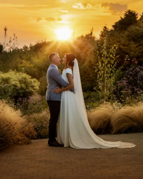 Couple embracing at sunset in lush garden setting near Fernhill House Hotel.