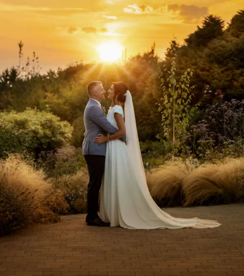 Couple embracing at sunset in lush garden setting near Fernhill House Hotel.