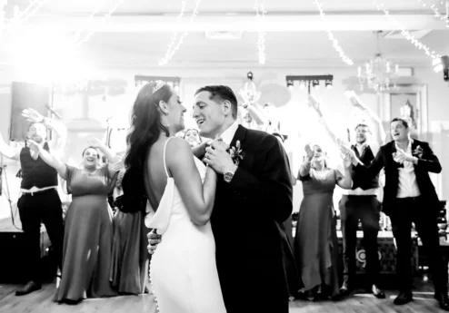 A couple shares their first dance at Fernhill House Hotel with joyful guests applauding.