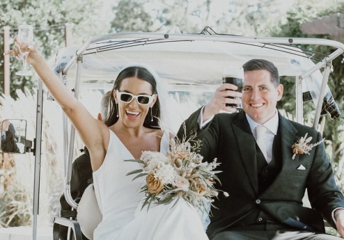 A joyful couple celebrating on a golf cart at Fernhill House Hotel.