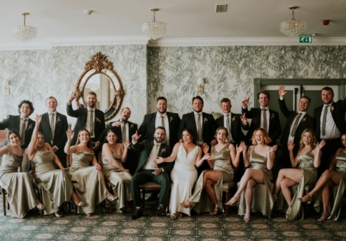 A joyous group of people in formal attire celebrating at Fernhill House Hotel.
