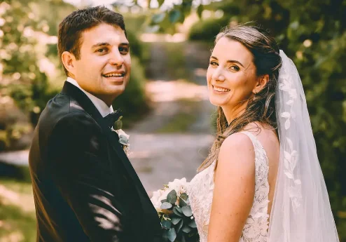 A joyous couple on their wedding day at Fernhill House Hotel, surrounded by lush greenery.