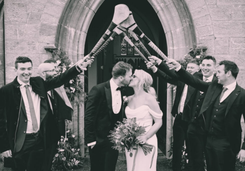 Couple kisses under arch of hurleys at Fernhill House Hotel.