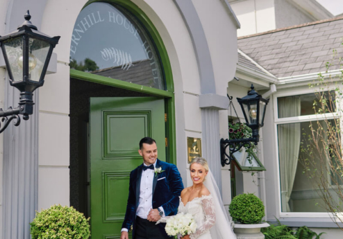 Couple in wedding attire at Fernhill House Hotel entrance.