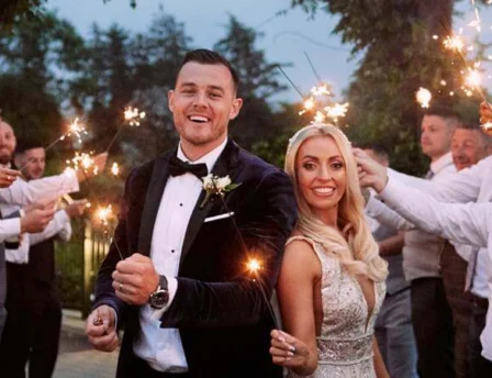 A joyful couple surrounded by family holding sparklers at Fernhill House Hotel wedding.