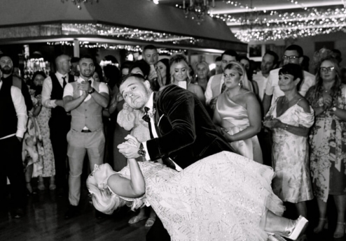 A couple dances joyfully under twinkling fairy lights at Fernhill House Hotel.