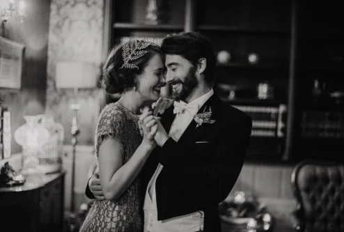 A smiling couple dances closely in an elegant, warmly lit room at Fernhill House Hotel.