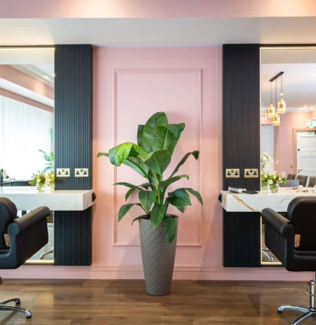 Elegant salon chairs in a stylish pink and black hotel spa.
