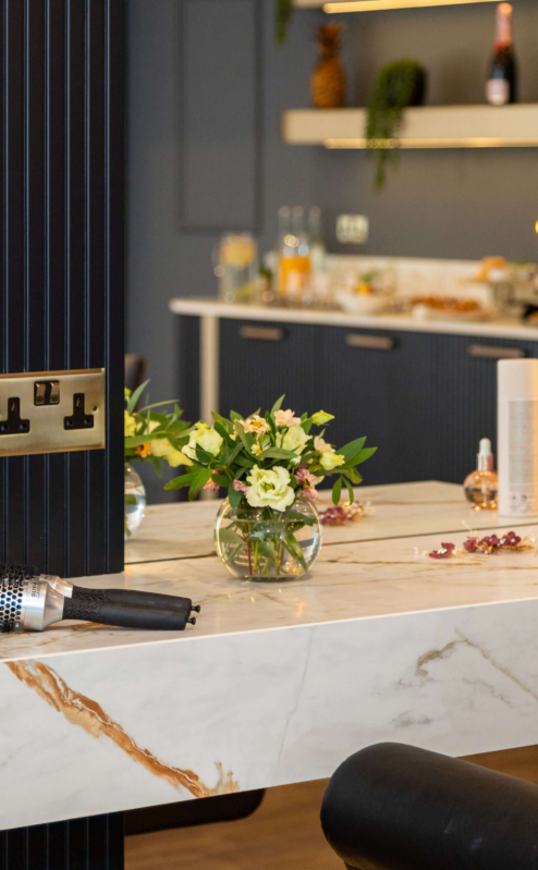 Stylish salon area with fresh flowers and hair products at Fernhill House Hotel.