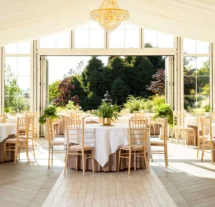 Elegant garden-view dining area with tables set for a family gathering.