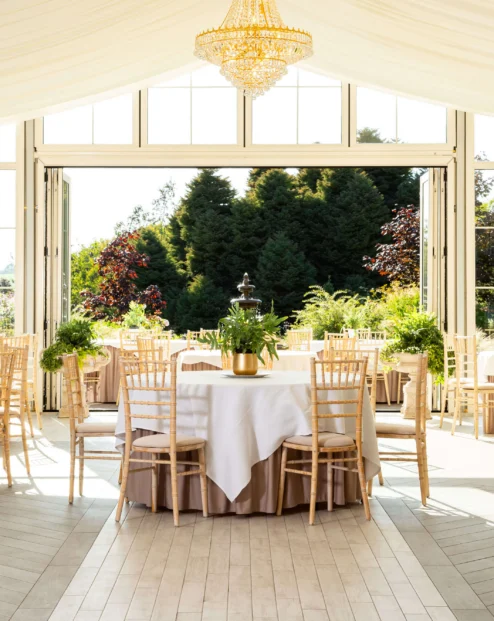 Elegant garden-view dining area with tables set for a family gathering.